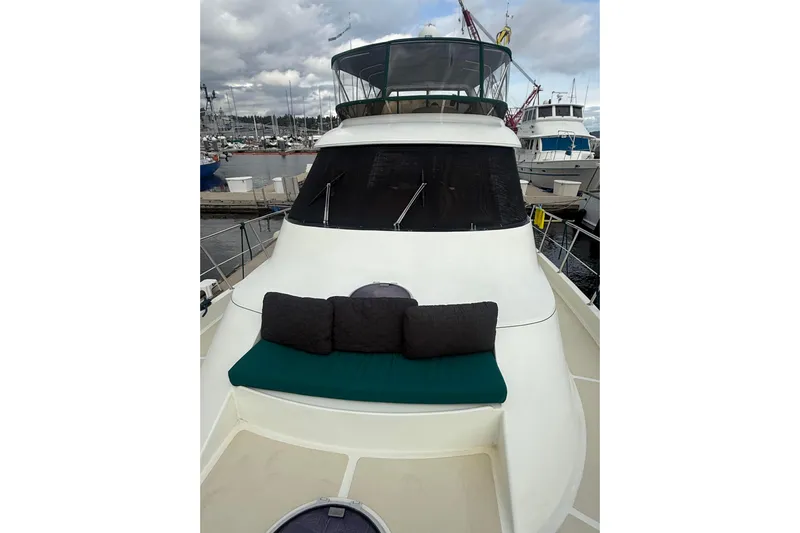 Eagles Soar Yacht Photos Pics 2000 Hampton 490 yacht with cushioned seating, docked at a marina under cloudy skies.