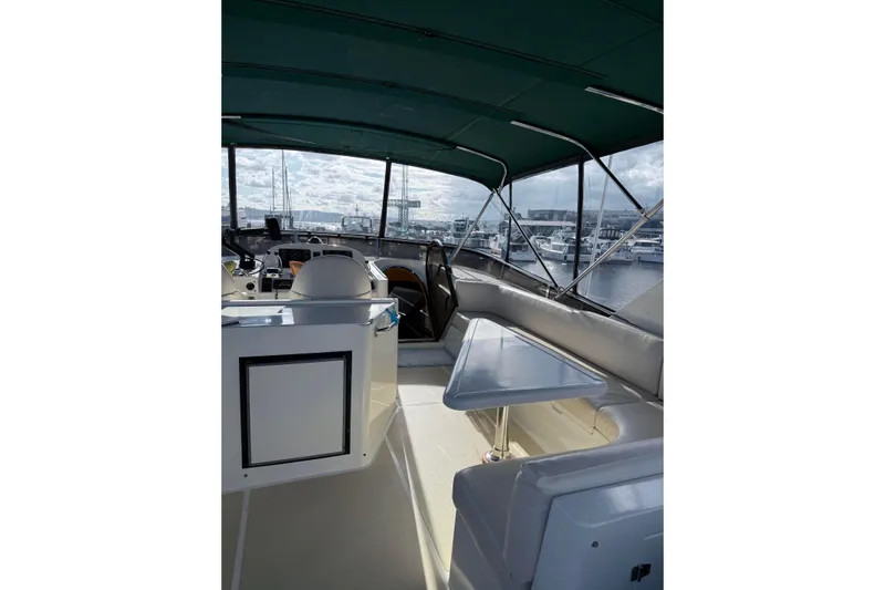 Eagles Soar Yacht Photos Pics Interior view of 2000 Hampton 490 yacht with seating and table under green canopy.