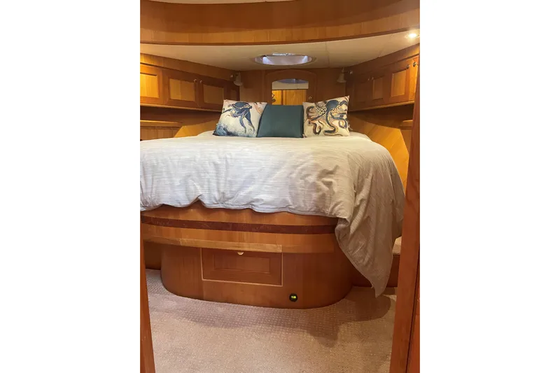 Eagles Soar Yacht Photos Pics Luxurious bedroom interior of 2000 Hampton 490 yacht with cozy bedding and wooden cabinetry.