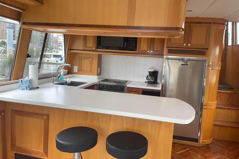 Eagles Soar Yacht Photos Pics Luxurious 2000 Hampton 490 yacht kitchen with modern appliances and wood cabinetry.