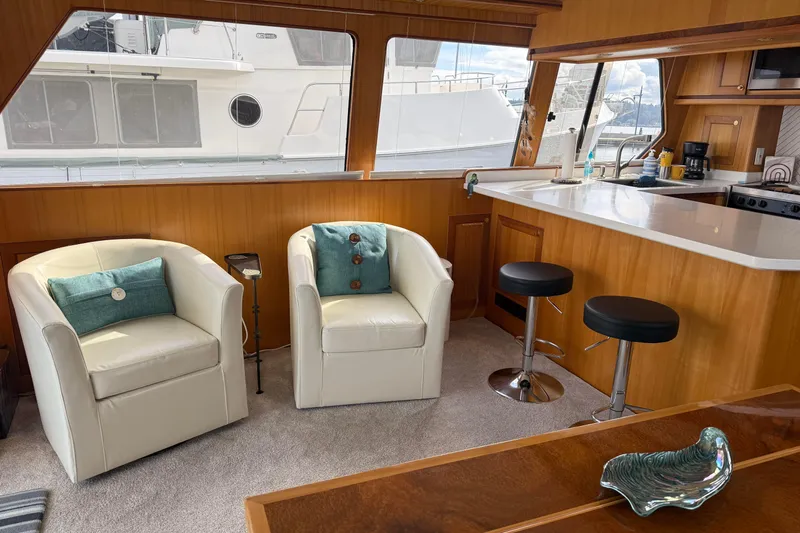 Eagles Soar Yacht Photos Pics Luxurious interior of a 2000 Hampton 490 yacht with white chairs and modern kitchen.