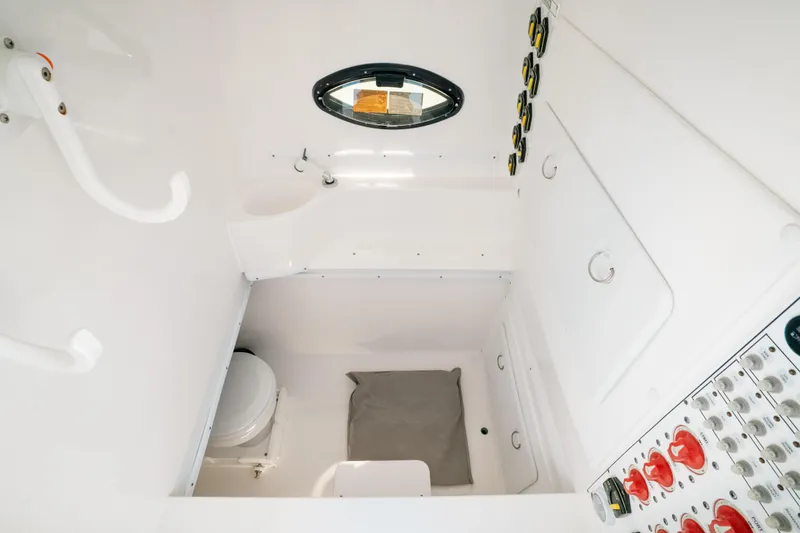 Yacht Photos Pics 2023 Contender 39 ST boat interior with toilet, control panel, and porthole window.