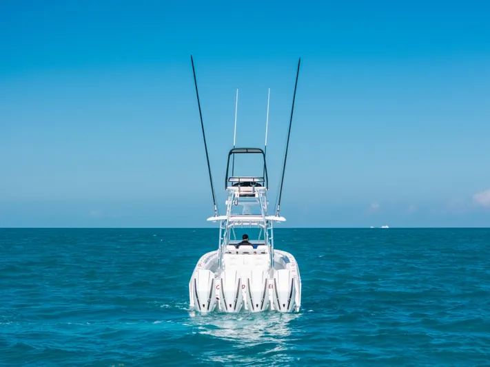  Yacht Photos Pics 2023 Contender 39 ST boat on open sea, rear view, clear blue sky.
