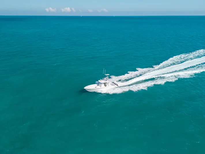  Yacht Photos Pics 2023 Contender 39 ST boat cruising on open turquoise sea.