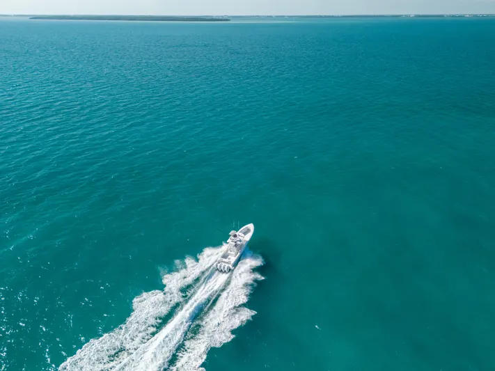  Yacht Photos Pics Aerial view of 2023 Contender 39 ST boat cruising on open turquoise sea.