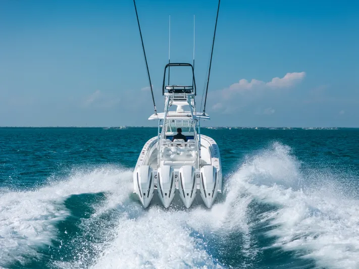  Yacht Photos Pics 2023 Contender 39 ST boat speeding on open ocean, creating dynamic water spray.