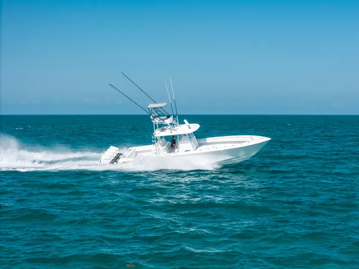  Yacht Photos Pics 2023 Contender 39 ST boat speeding on open ocean under clear blue sky.