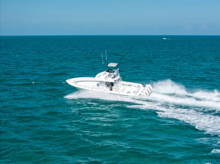  Yacht Photos Pics 2023 Contender 39 ST boat cruising on open ocean waters.