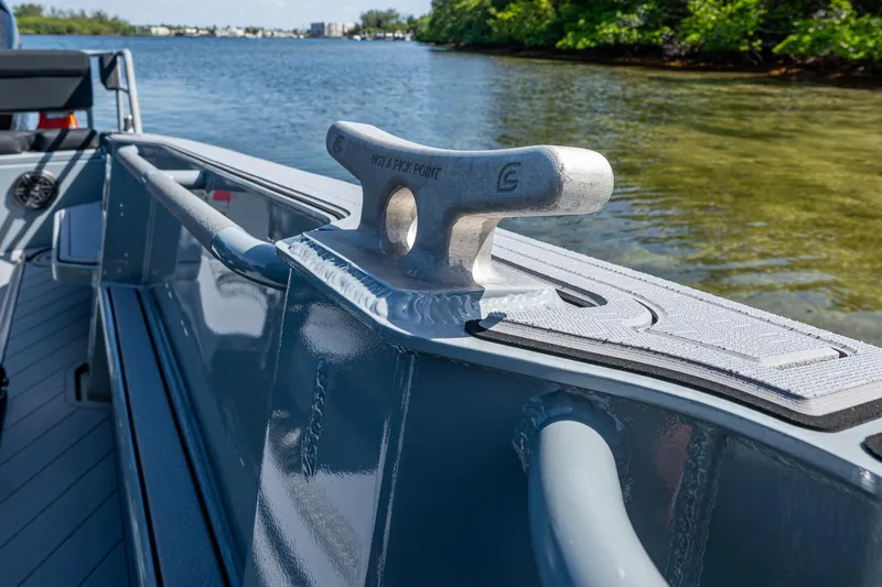  Yacht Photos Pics 2023 SAFE Boats Interceptor cleat on deck, near calm water and lush shoreline.