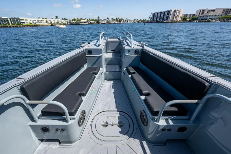  Yacht Photos Pics 2023 SAFE Boats Interceptor interior with seating, on calm water, near waterfront buildings.