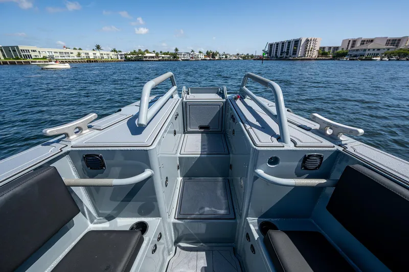  Yacht Photos Pics 2023 SAFE Boats Interceptor on water, showcasing interior seating and railing, with waterfront buildings in background.