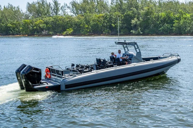  Yacht Photos Pics 2023 SAFE Boats Interceptor cruising on a calm river with lush green trees in the background.