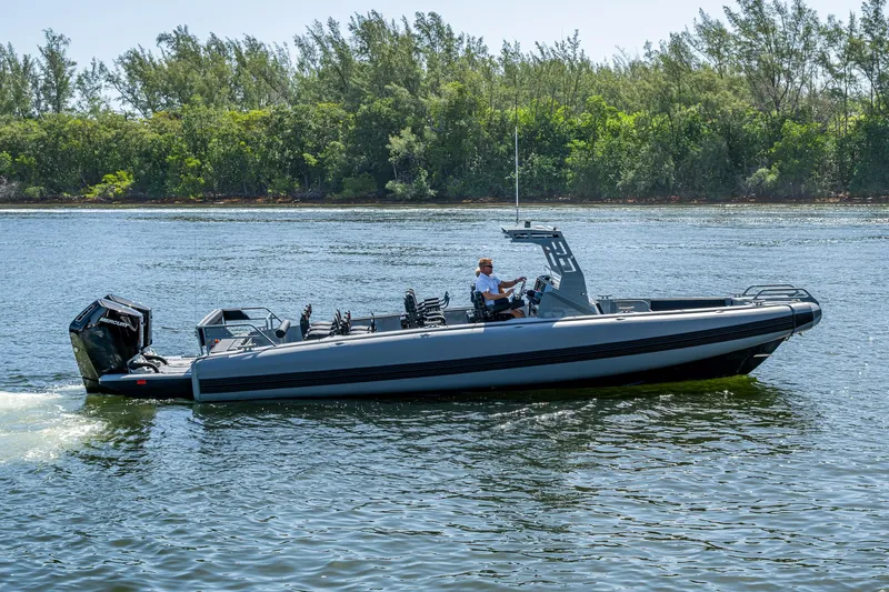  Yacht Photos Pics 2023 SAFE Boats Interceptor on water, with lush green trees in the background.