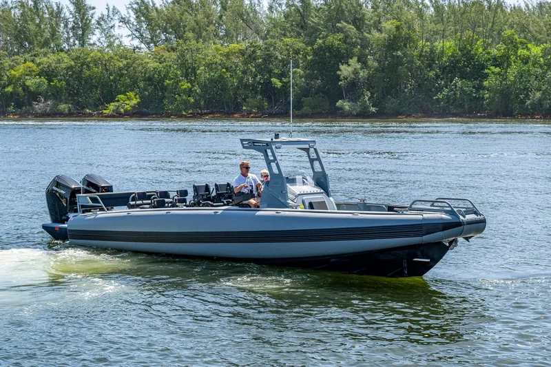  Yacht Photos Pics 2023 SAFE Boats Interceptor cruising on a calm river with lush green trees in the background.