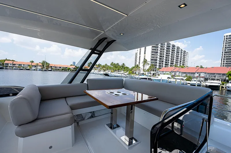 Miss K Yacht Photos Pics Luxurious seating area on 2022 Prestige 520 Fly yacht, docked near waterfront buildings.