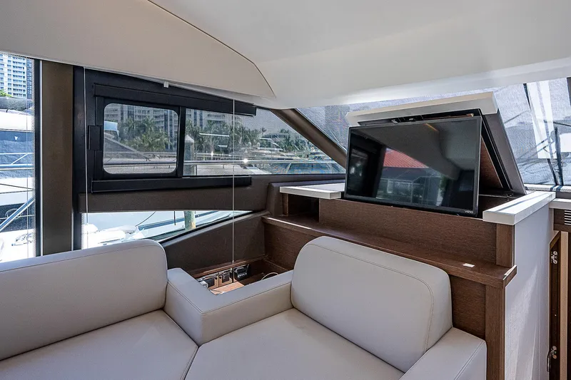 Miss K Yacht Photos Pics Luxurious interior of 2022 Prestige 520 Fly yacht with modern seating and pop-up TV.