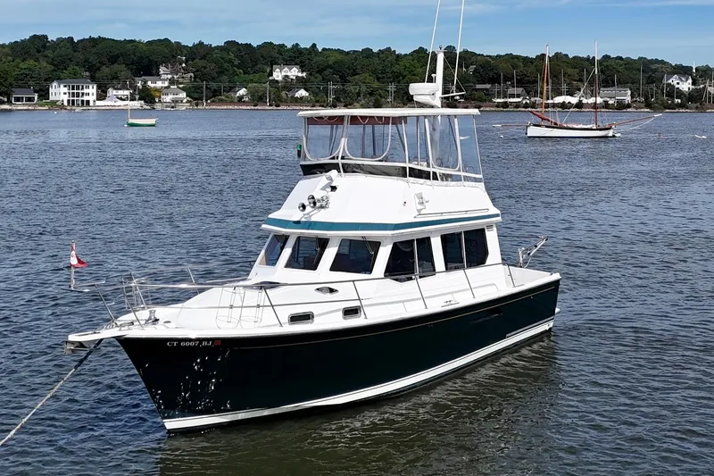 Daystar Yacht Photos Pics 2001 Sabre Sabreline 34 boat anchored on calm water with scenic shoreline background.