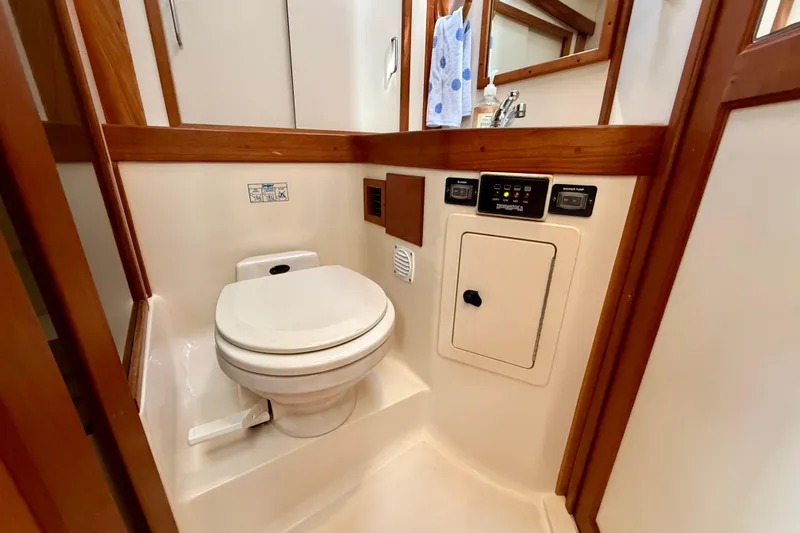 Daystar Yacht Photos Pics 2001 Sabreline 34 yacht bathroom with toilet, wooden accents, and control panels.