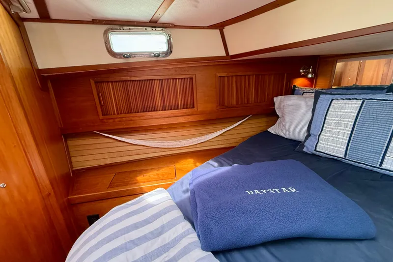 Daystar Yacht Photos Pics Cozy cabin interior of 2001 Sabre Sabreline 34 with wooden accents and nautical bedding.