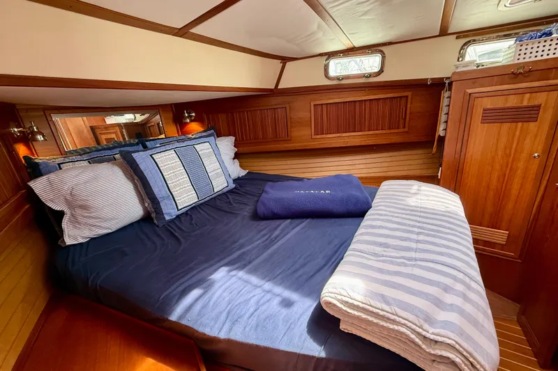 Daystar Yacht Photos Pics Cozy cabin interior of 2001 Sabre Sabreline 34 yacht with wooden paneling and comfortable bedding.