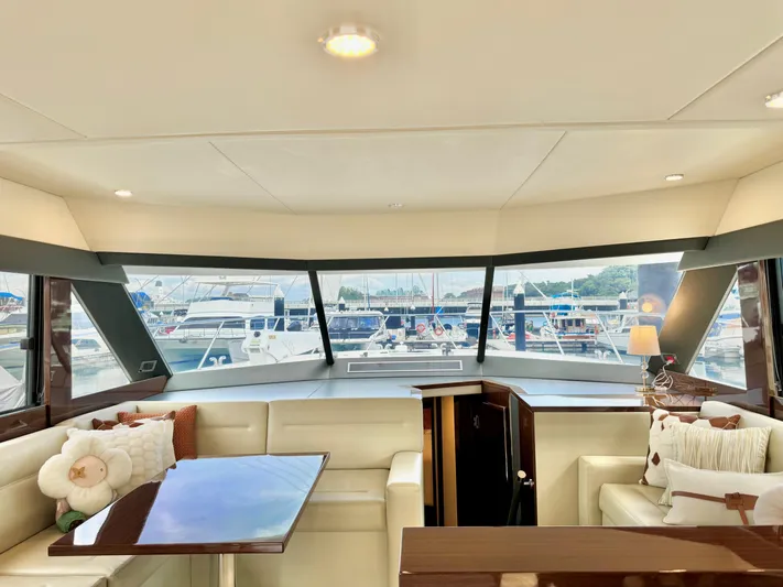 Waves III Yacht Photos Pics Luxurious interior of 2017 Maritimo M51 yacht with marina view through large windows.
