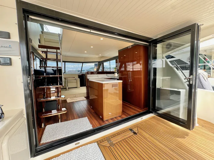 Waves III Yacht Photos Pics Interior view of 2017 Maritimo M51 yacht with open sliding doors and wooden flooring.