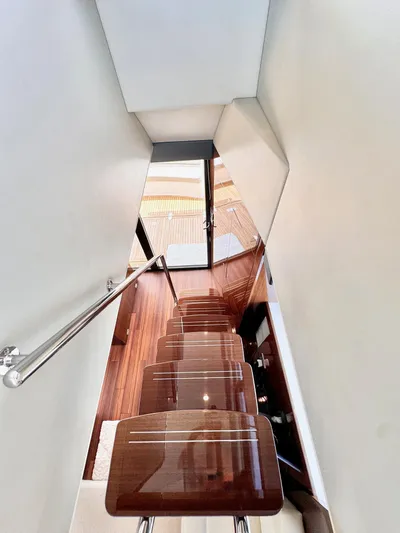 Waves III Yacht Photos Pics Staircase inside 2017 Maritimo M51 yacht with polished wooden steps and sleek railing.