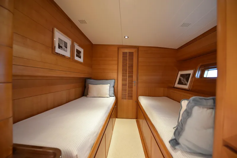 Green Eyes Yacht Photos Pics Cozy twin cabin interior on 2001 Wally Full Displacement Sailing Yacht, featuring wooden paneling and framed art.