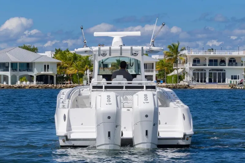  Yacht Photos Pics 2023 HCB 39 Speciale boat cruising near waterfront homes, featuring dual V12 engines.