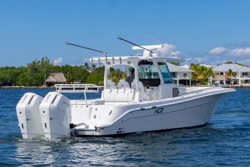  Yacht Photos Pics 2023 HCB 39 Speciale boat cruising on a sunny day near waterfront homes.