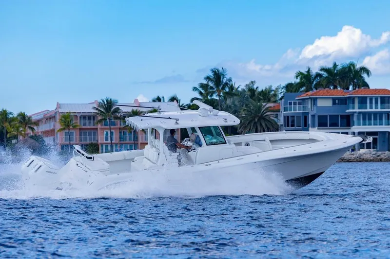  Yacht Photos Pics 2023 HCB 39 Speciale boat cruising on water near luxury waterfront homes.