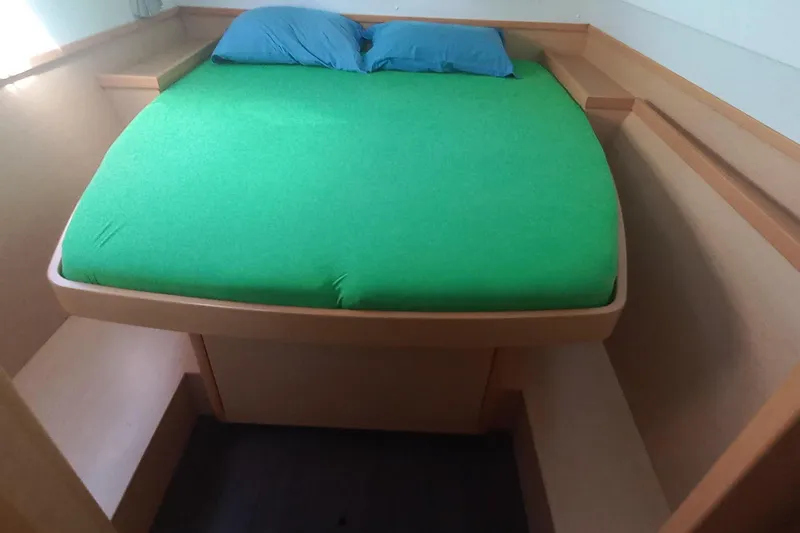 Benetnash II Yacht Photos Pics Cabin interior of 2016 Lagoon 42 catamaran with green bedding and blue pillows.