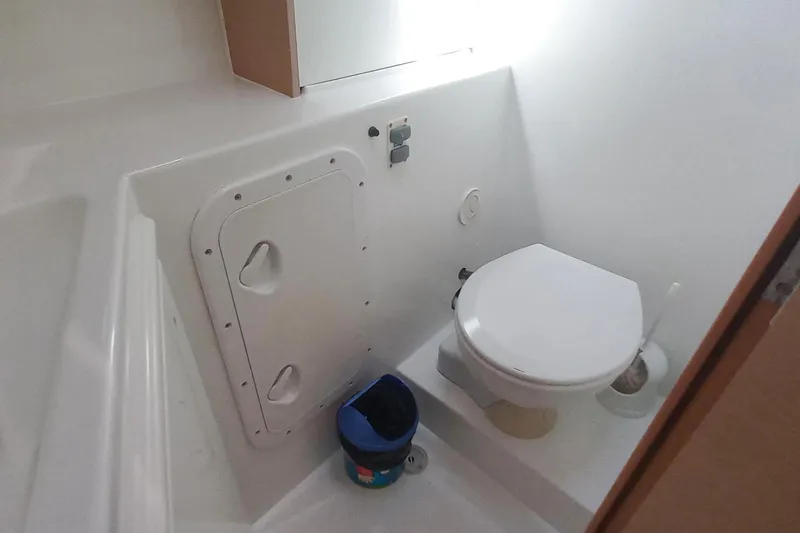 Benetnash II Yacht Photos Pics Compact bathroom in a 2016 Lagoon 42 catamaran, featuring a toilet and storage compartment.