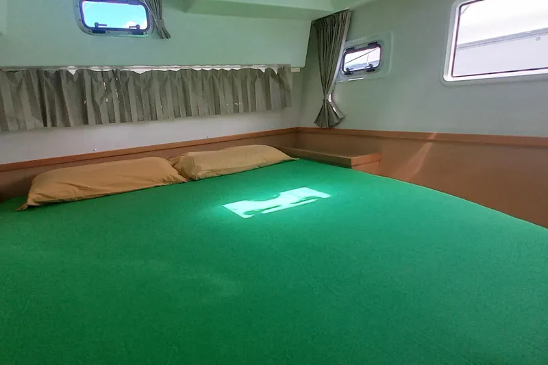 Benetnash II Yacht Photos Pics Cozy cabin interior of 2016 Lagoon 42 catamaran with green bedding and windows.