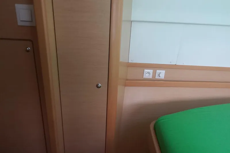 Benetnash II Yacht Photos Pics Interior of 2016 Lagoon 42 yacht cabin with green bedding and wooden paneling.