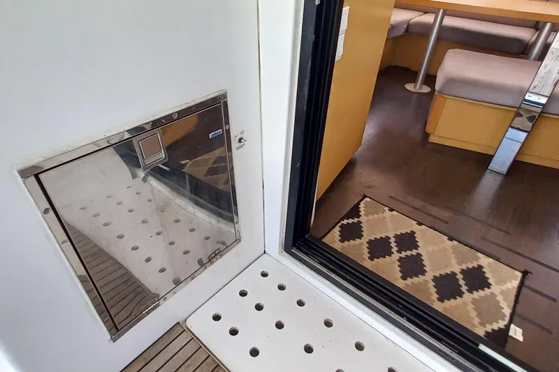 Benetnash II Yacht Photos Pics Interior view of 2016 Lagoon 42 catamaran, featuring a cozy seating area and patterned rug.