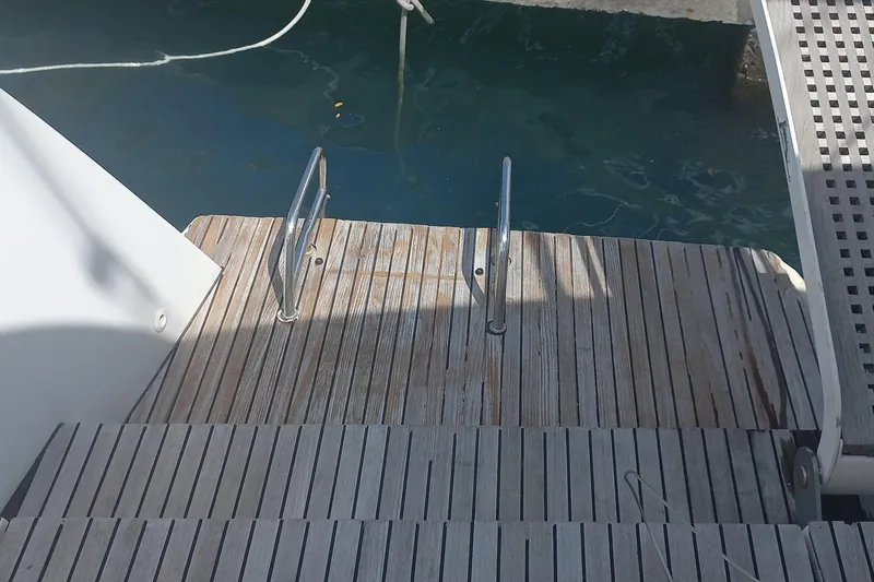 Benetnash II Yacht Photos Pics Wooden deck steps on a 2016 Lagoon 42 catamaran leading to the water.