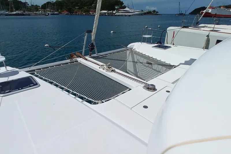 Benetnash II Yacht Photos Pics 2016 Lagoon 42 catamaran on calm waters, featuring spacious deck and netting.