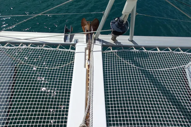 Benetnash II Yacht Photos Pics Catamaran Lagoon 42 (2016) bow with netting and anchor over turquoise water.