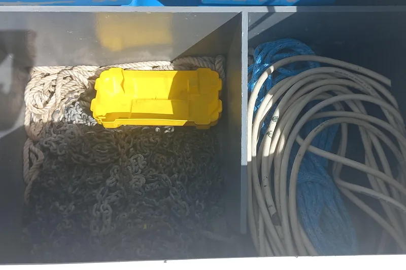 Benetnash II Yacht Photos Pics Storage compartment on a 2016 Lagoon 42 with ropes, chains, and a yellow container.