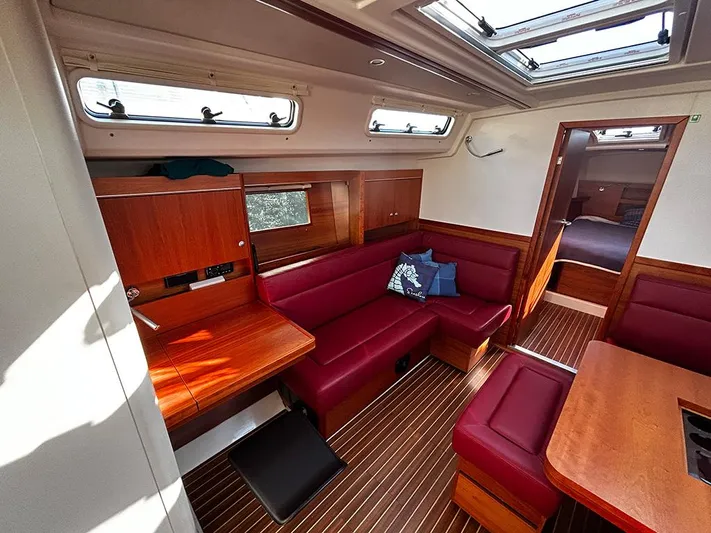 Alegrea III Yacht Photos Pics Interior of a 2016 Hanse 455 yacht with red sofa and wooden furnishings.
