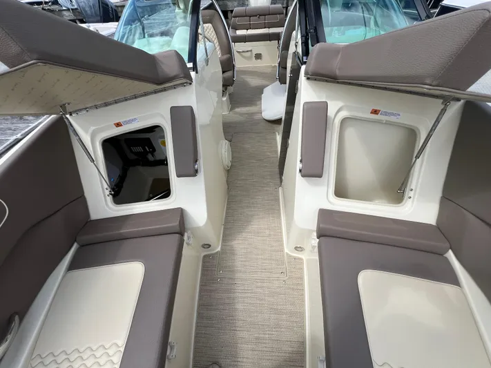  Yacht Photos Pics 2023 Chris-Craft Launch 28 GT interior with beige and brown seating, open storage compartments.