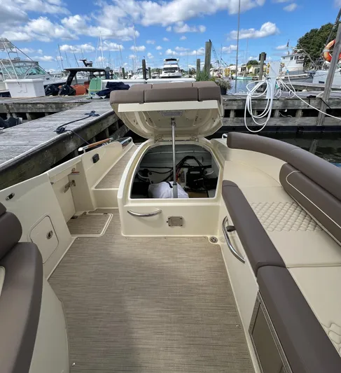  Yacht Photos Pics 2023 Chris-Craft Launch 28 GT boat interior at marina, open storage compartment, clear sky.