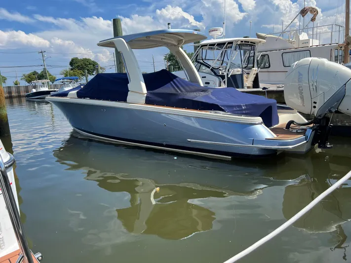  Yacht Photos Pics 2023 Chris-Craft Launch 28 GT boat docked in marina, covered with blue tarp.
