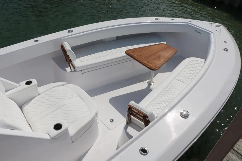  Yacht Photos Pics Luxurious seating area on 2026 Bahama 41 GT boat with elegant white upholstery and wooden table.