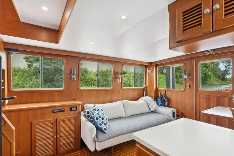 Seabatical Yacht Photos Pics Luxurious interior of 2008 North Pacific 43 Pilothouse with wooden finishes and large windows.