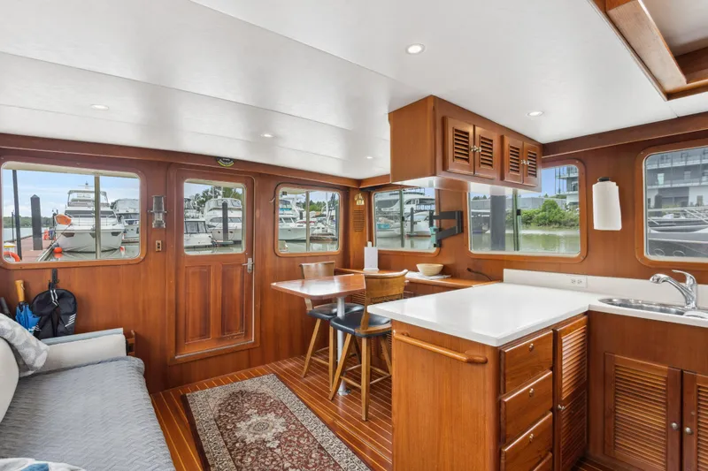 Seabatical Yacht Photos Pics Interior of 2008 North Pacific 43 Pilothouse yacht with wooden cabinetry and seating area.