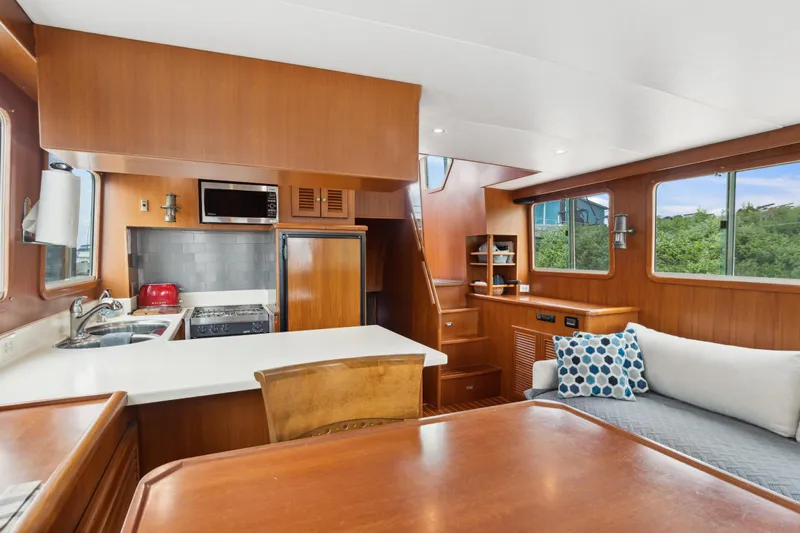 Seabatical Yacht Photos Pics Interior of 2008 North Pacific 43 Pilothouse with kitchen and seating area.