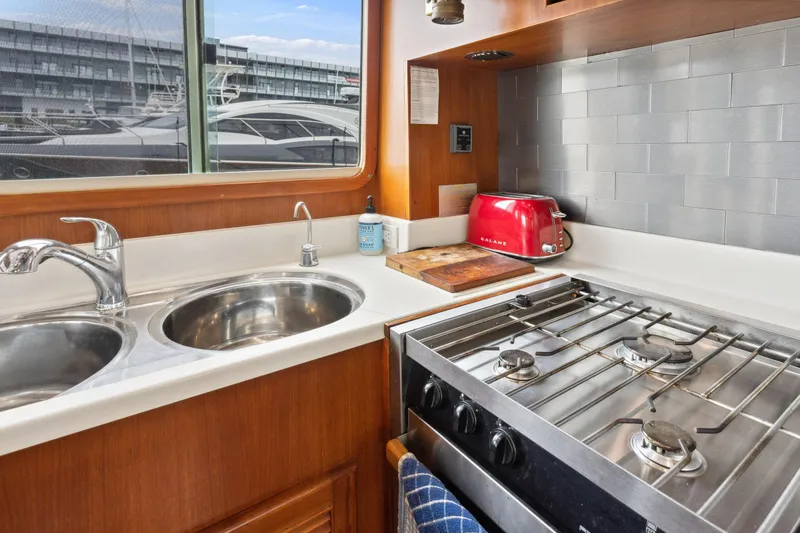 Seabatical Yacht Photos Pics Galley kitchen in 2008 North Pacific 43 Pilothouse with stove, sink, and red toaster.