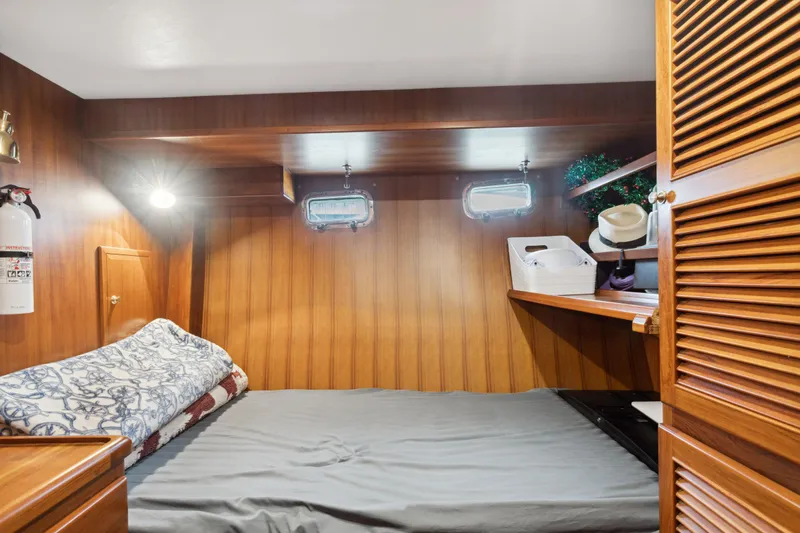 Seabatical Yacht Photos Pics 2008 North Pacific 43 Pilothouse cabin with wood paneling and cozy bed.